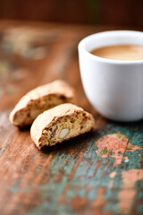 Cantuccini (Italian cookie) and a cup of coffee on dark wooden background. Close up.	