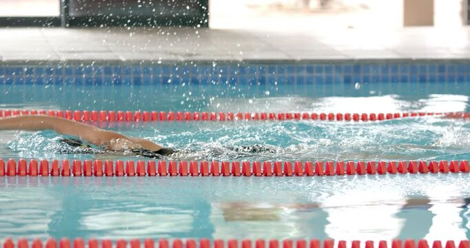 Swimming in pool, athlete practicing freestyle stroke during training session