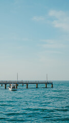 Obraz premium A bridge that stretches out over the sea, offering a view of the sunset in the evening.View of Bangsaen Beach, Chonburi Thailand.