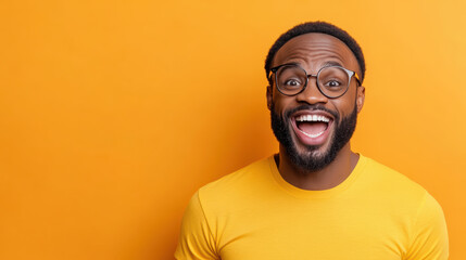 Obraz premium Man smiling joyfully on bright orange background, expressing happiness