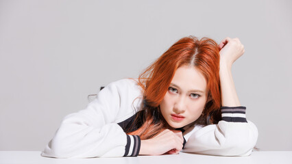 Fototapeta premium Close up fashion beauty portrait of asian sexy attractive cheerful confident young woman with long orange hair and glowing skin healthy, model looking camera posing in studio setting white background.