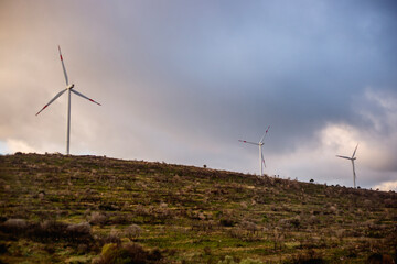 Windmills on landscape against stormy sky background