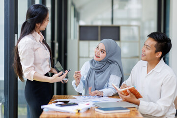 Obraz premium Financial Advisor discussion group of four happy young asian corporate people teammates meeting discussing business in the workplace office. 