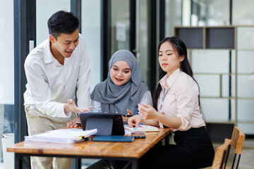 Financial Advisor discussion group of four happy young asian corporate people teammates meeting discussing business in the workplace office.
