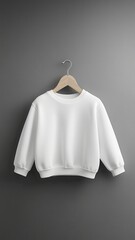 A simple white sweatshirt hangs on a wooden hanger against a textured gray wall, showcasing a clean and minimalist style.