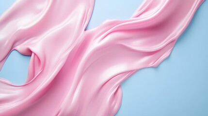 Obraz premium Pink silk fabric draped elegantly on blue background