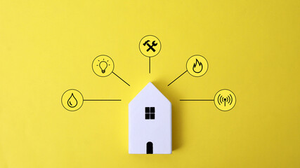Miniature house and symbols of public utilities on a yellow background Top view Flat lay