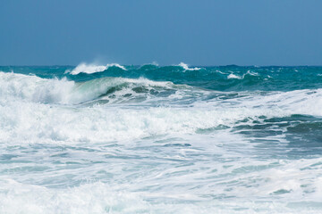 Waves on the beach in windy day. Blue sea and the blue sky.