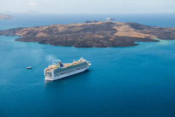 Santorini island, Greece. Cruise ship near the coast. Blue sea and the blue sky.