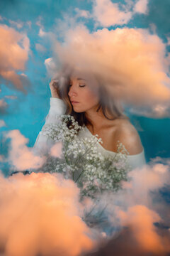 Woman holding flowers with her head in the clouds