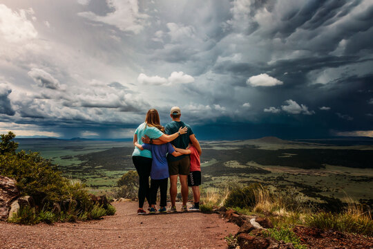 Family Standing on Mountain top looking at oncoming storm
