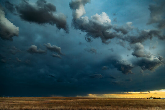 Dark Ominous Clouds with rain in the distance over prairie land