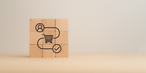 Customer Journey Concept. Customer journey on wooden blocks with icons of a user, shopping cart, and checkmark. Business and marketing strategy, e-commerce processes and consumer engagement.