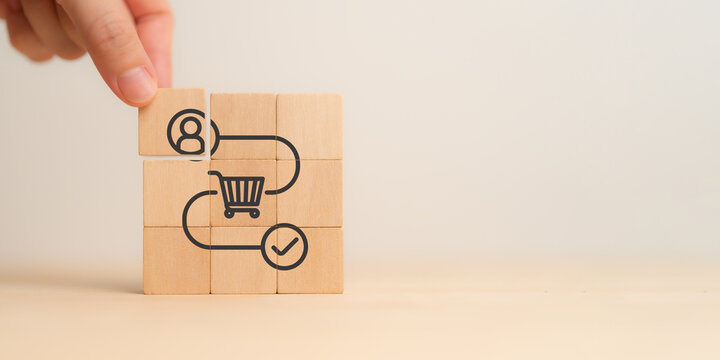 Customer Journey Concept. Customer journey on wooden blocks with icons of a user, shopping cart, and checkmark. Business and marketing strategy, e-commerce processes and consumer engagement.