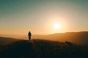Fototapeta premium Silhouette of a person in the sunset biking in the mountain 