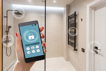 Young woman holding smart phone with launched security application at home. Concept of controlling and managing home security from a mobile device