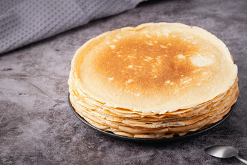 Stack of traditional russian pancakes blini on gray background. Homemade russian thin pancakes...