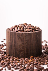 many macro aromatic, coffee beans in a wooden cup on a white background