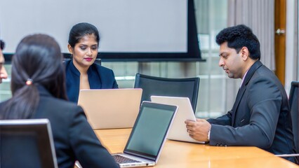 Obraz premium Business Meeting with Laptop – Indian professionals discussing strategies while using laptops and digital tools in a conference room. 