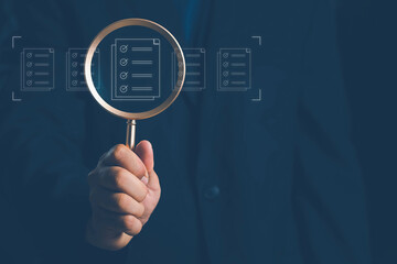 Man holding a magnifying glass, showing Audit Document concept,quality assessment management With a checklist, business document evaluation process, market data report analysis and consulting