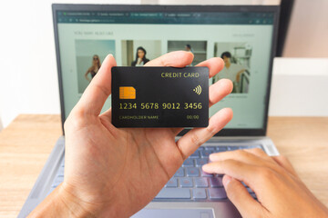 Pov first person holding black mockup credit card while typing for online shop on laptop in home