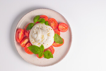 Delicious Italian caprese salad with sliced mozzarella, tomatoes, basil, and bread on background. 
