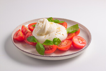 Delicious Italian caprese salad with sliced mozzarella, tomatoes, basil, and bread on background. 