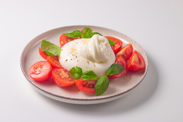 Delicious Italian caprese salad with sliced mozzarella, tomatoes, basil, and bread on background. 