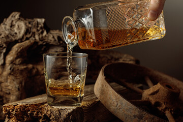 Whiskey is poured from a decanter into a glass.