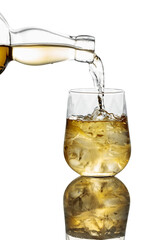 Pouring Whiskey from a bottle into a glass with ice on a white background.