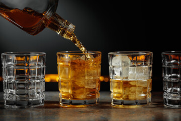 Whiskey is poured into a glass with ice.