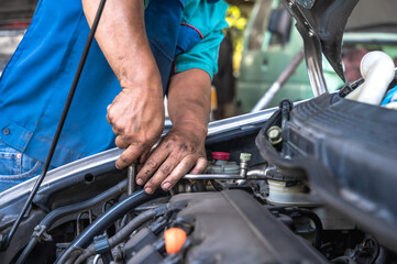 Close up local car mechanic fixing car in auto repair service shop