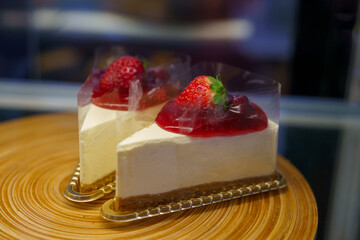 Two pieces of strawberry cheesecake, topped with strawberry jam and fresh strawberries.