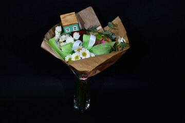 Beautifully colored wedding bouquet with wooden house.