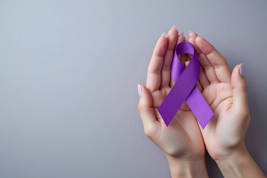 World cancer day, hands holding purple ribbon on grey background with copy space for text. Healthcare and medical concept.