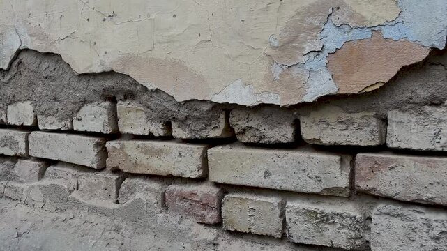 Background of a crumbling brick wall close-up. The texture of a crumbling wall