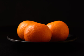 Fresh mandarin oranges healthy fruit on black background.