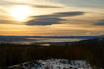 Fototapeta premium Majestic Sunset View from Norefjell Mountain: A Winter Evening Above the Clouds Over the Valley and Lake Krøderen in Norway