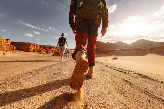 Silhouette of close up hikers legs is going with tourist group walking in desert. Gobi desert, Mongolia