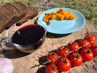 Hard cheese on a plate next to tomatoes and wine. High quality photo