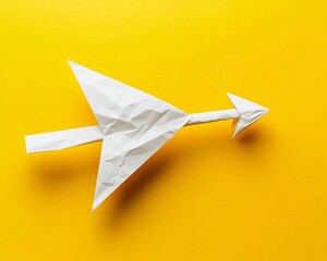 Abstract Crumpled Paper Arrow on Yellow Background