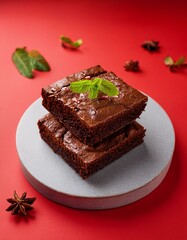 Fresh pieces of delicious chocolate brownies on red background