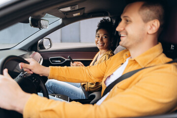 Happy young couple traveling by their new electric car