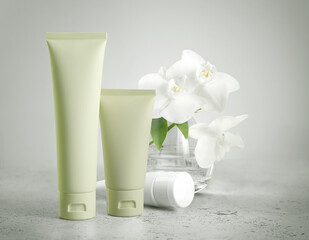 Green tubes standing on green background, offering blank space for branding of skincare or cosmetic product. Template for design, mockup. Natural Beauty concept