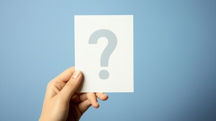 Hand Holding White Question Mark Card Against Light Blue Background