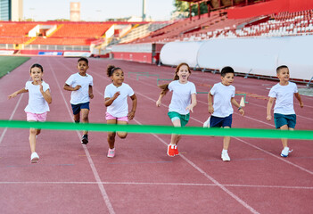child sport athlete competition running race exercise sprinting speed runner achievement finish line celebration challenge champion goal ribbon success
