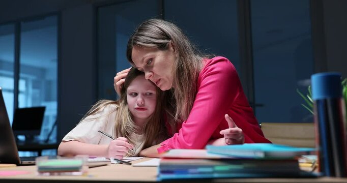 Supportive mother comforts and assists daughter with schoolwork at desk. Challenges of home education and parental support concept slow motion