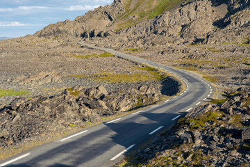 The narrow scenic road between Hamningberg and Vardø on a sunny summer evening. Varanger Peninsula, Norway