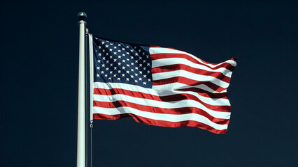 Fototapeta premium American Flag Waving Proudly: Stars and Stripes Symbol of Freedom, Patriotism, and National Pride Against a Deep Blue Sky Background