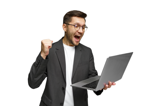 Excited young man celebrates success while using laptop in a modern workspace